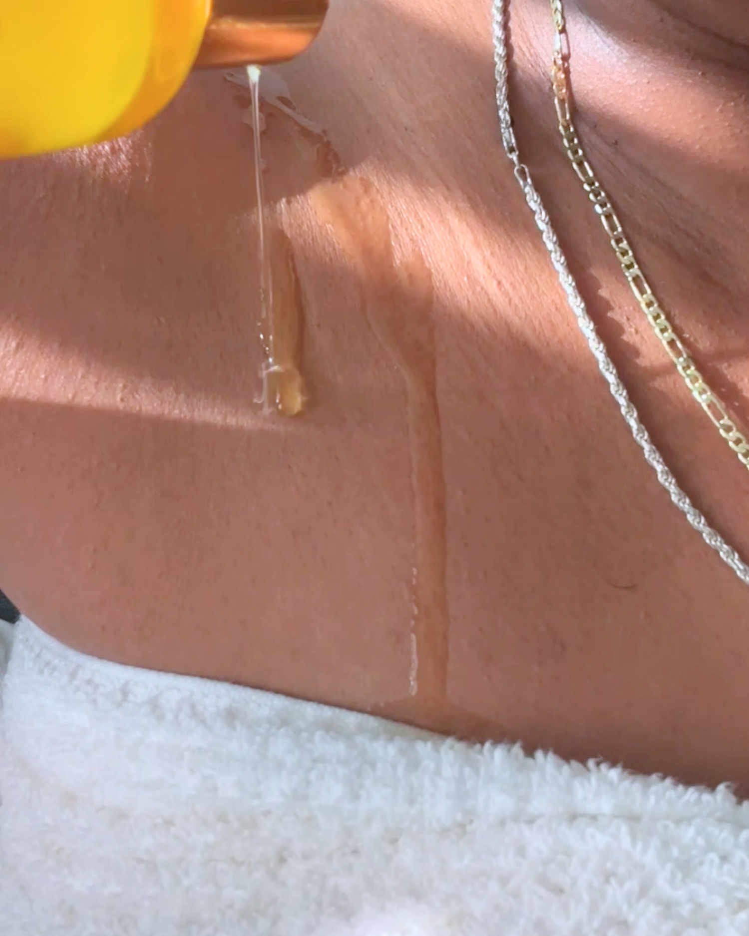 Person applying body oil to their shoulder.